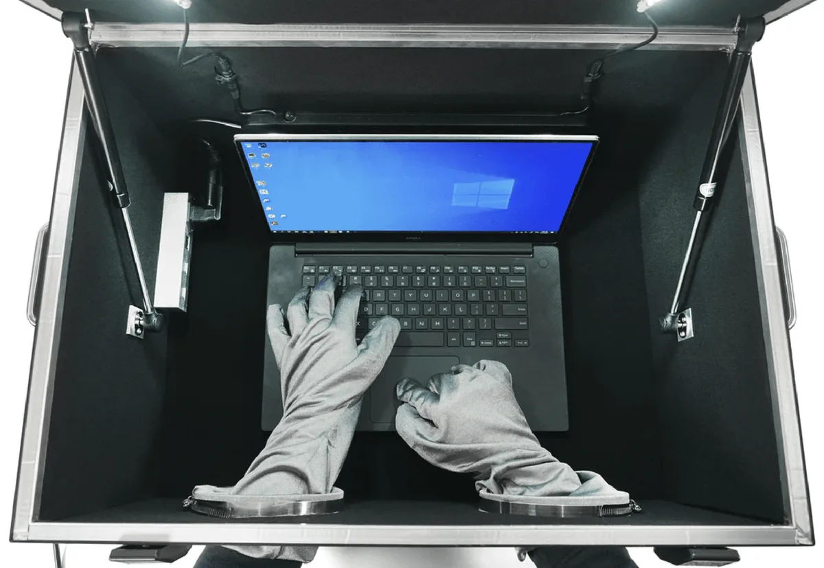Un ordinateur portable manipulé avec les gants intégrés de la BlockBox Lab XL