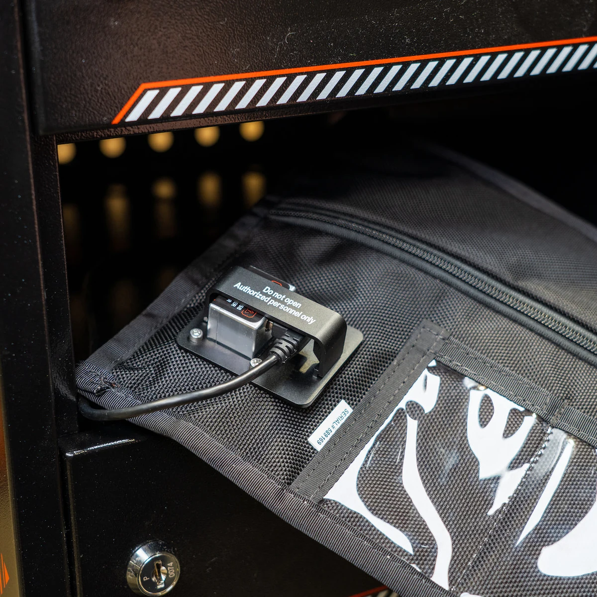 Le sac Charge & Shield dans son compartiment, câble branché et verrou de câble en place