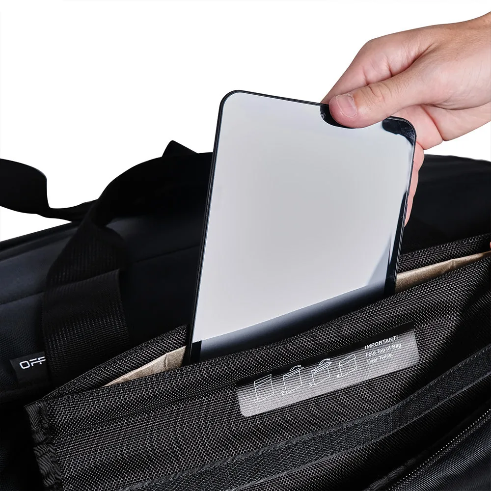 Une tablette glissée dans la poche blindée pour tablette du sac Faraday Duffel