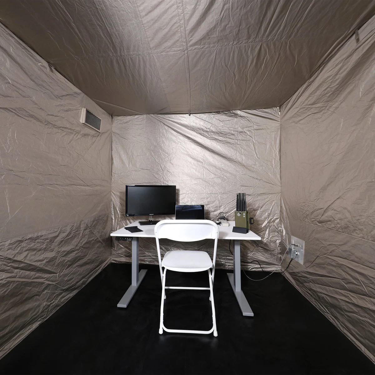 L’intérieur de la tente de Faraday d’OffGrid, aménagé d’un bureau, d’une chaise et d’un poste de travail
