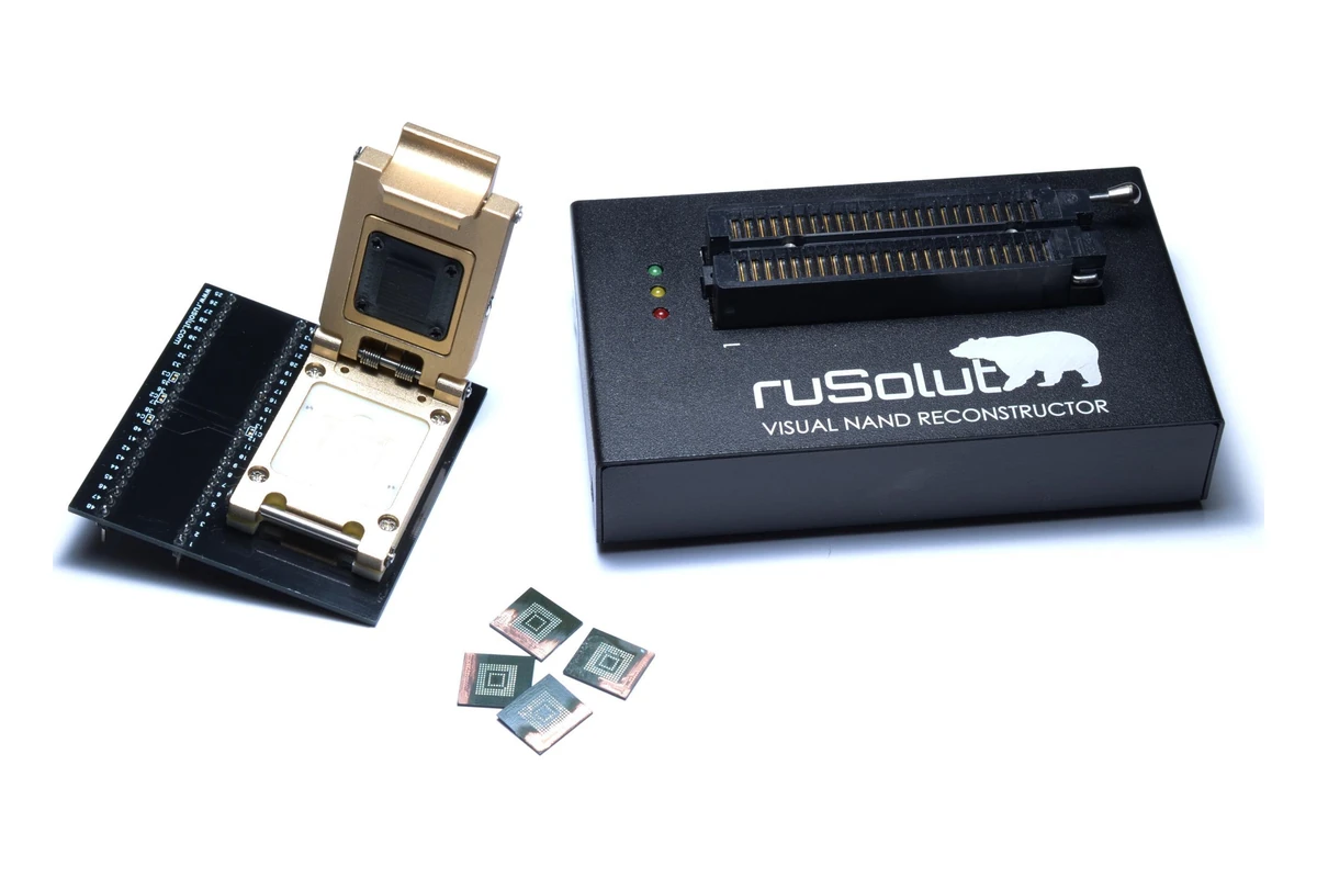 Le lecteur Rusolut et un adaptateur eMMC-NAND au support ouvert, devant quelques puces eMMC dessoudées