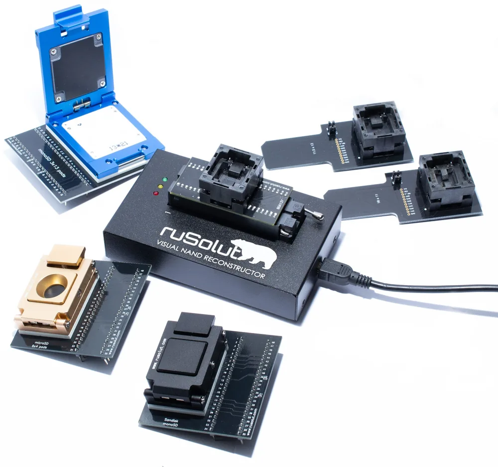 Le lecteur NAND Rusolut, un adaptateur BGA enfiché, entouré d’autres adaptateurs BGA et d’un support monolithe ouvert